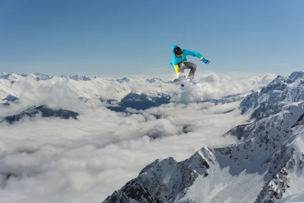 Snowboard jezdec skákat na horách. Extrémní snowboard freeride sport. — Stock fotografie