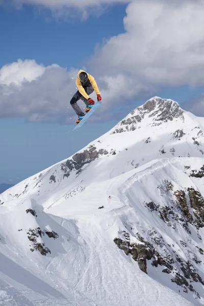 Cavaleiro de snowboard pulando em montanhas. Esporte de freeride de snowboard extremo. — Fotografia de Stock