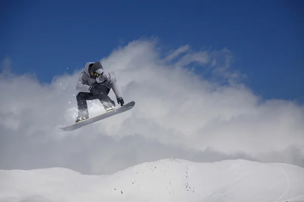 Καβαλάρης snowboard πηδάει στα βουνά. Extreme snowboard ελεύθερο άθλημα. — Φωτογραφία Αρχείου