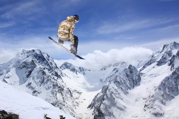 스노보드를 타고 산에 뛰어오르는 사람. 극도의 스노보드 프리에 이드 스포츠. — 스톡 사진