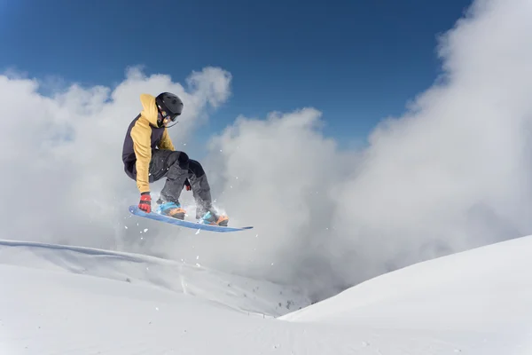 Καβαλάρης snowboard πηδάει στα βουνά. Extreme snowboard ελεύθερο άθλημα. — Φωτογραφία Αρχείου