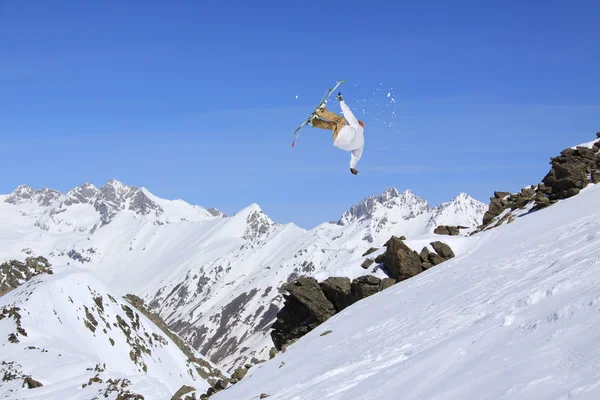 Cavaleiro de esqui a saltar sobre montanhas. Esporte de freeride de esqui extremo . — Fotografia de Stock