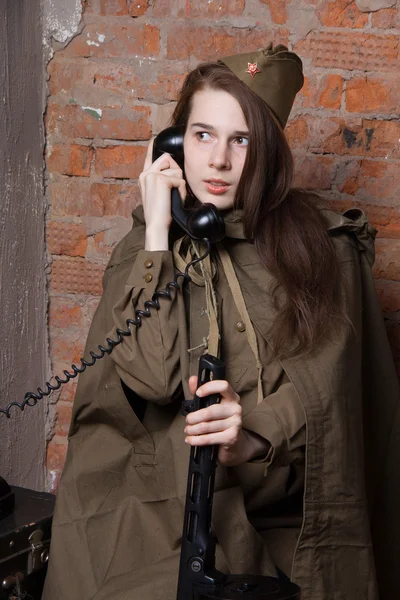 Woman in Russian military uniform speaks on phone. Female soldier during the second world war.