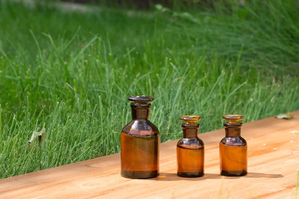 Kleine braune Flaschen auf Booden Board und Gras — Stockfoto