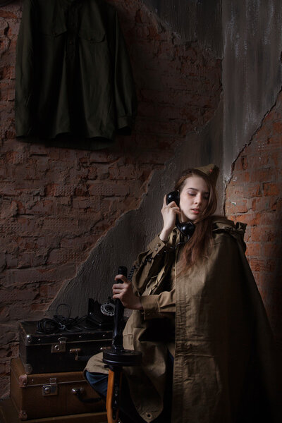 Woman in Russian military uniform speaks on phone. Female soldier during the second world war.