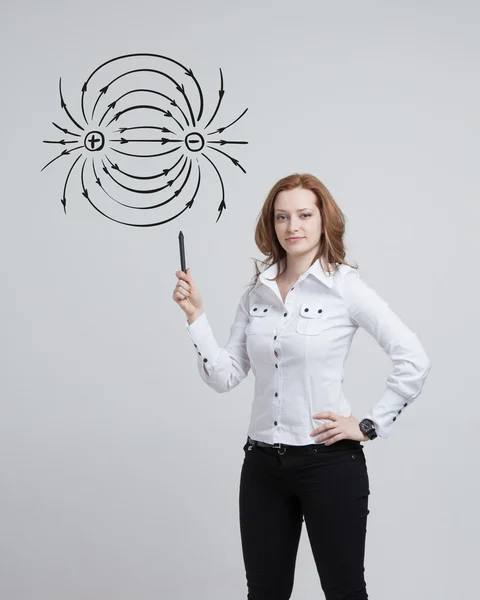 Junge Frau, Physiklehrerin zeichnet ein Diagramm des elektrischen Feldes — Stockfoto