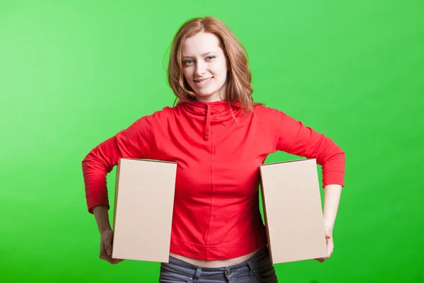 Woman holding cardboard boxes on green background — Stock Photo, Image