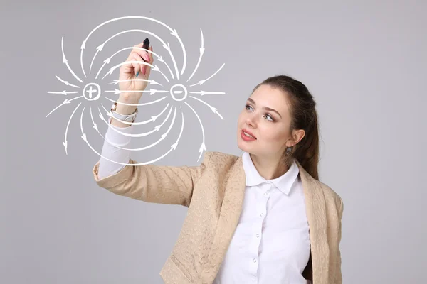 Junge Frau, Physiklehrerin zeichnet ein Diagramm des elektrischen Feldes — Stockfoto