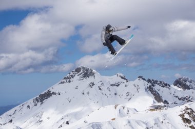 Dağlarda atlayan snowboard binicisi. Ekstrem snowboard serbest spor.
