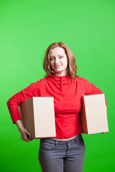 Woman holding cardboard boxes on green background — Stock Photo, Image