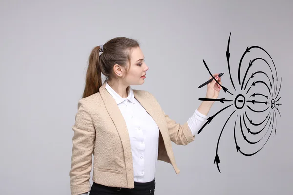 Jeune femme, professeur de physique dessine un diagramme du champ électrique — Photo