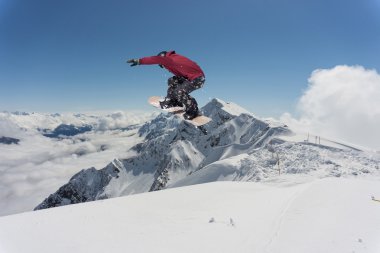 Dağlarda atlayan snowboard binicisi. Ekstrem snowboard serbest spor.