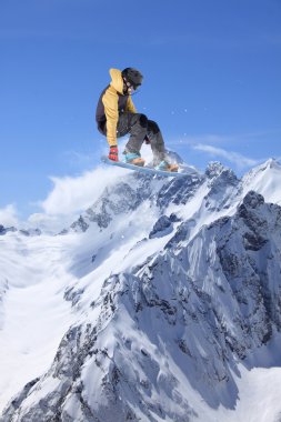 Dağlarda atlayan snowboard binicisi. Ekstrem snowboard serbest spor.