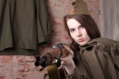 Rus askeri üniformalı kadın tüfekle vuruyor. İkinci Dünya Savaşı sırasında kadın asker.