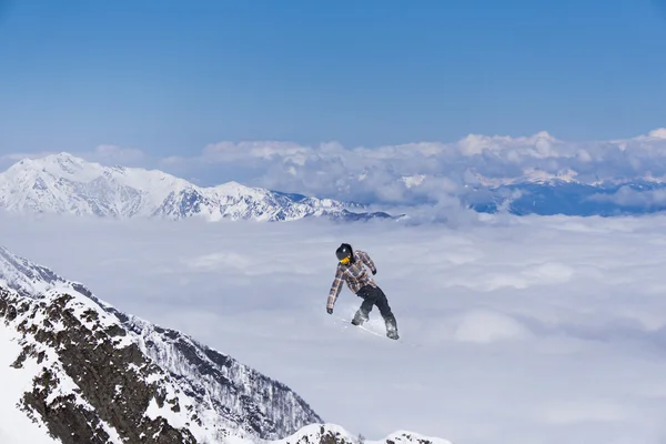 Καβαλάρης snowboard πηδάει στα βουνά. Extreme snowboard ελεύθερο άθλημα. — Φωτογραφία Αρχείου