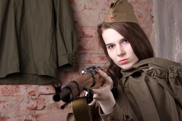 Una mujer con uniforme militar ruso dispara un rifle. Soldado femenino durante la Segunda Guerra Mundial . —  Fotos de Stock