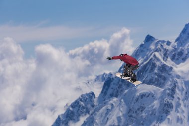 Dağlarda atlayan snowboard binicisi. Ekstrem snowboard serbest spor.