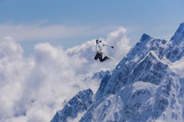 Dağlarda atlayan snowboard binicisi. Ekstrem snowboard serbest spor.