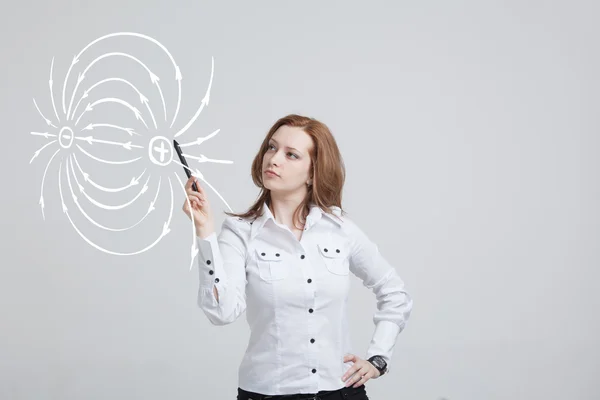 Junge Frau, Physiklehrerin zeichnet ein Diagramm des elektrischen Feldes — Stockfoto