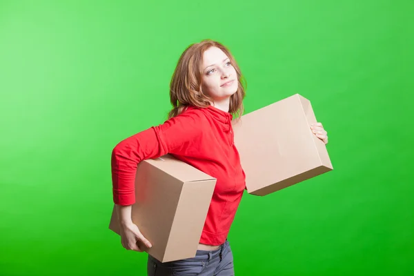 Woman holding cardboard boxes on green background — Stock Photo, Image