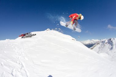 Dağlarda atlayan snowboard binicisi. Ekstrem snowboard serbest spor.