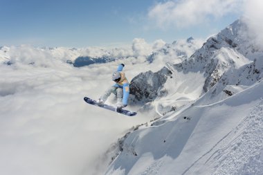 Dağlarda atlayan snowboard binicisi. Ekstrem snowboard serbest spor.