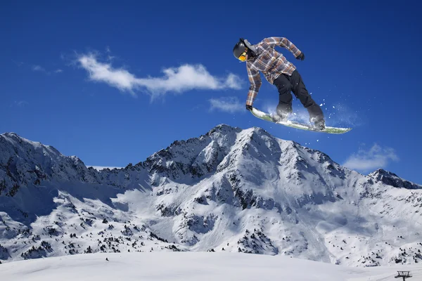 Cavaleiro de snowboard pulando em montanhas. Esporte de freeride de snowboard extremo. — Fotografia de Stock