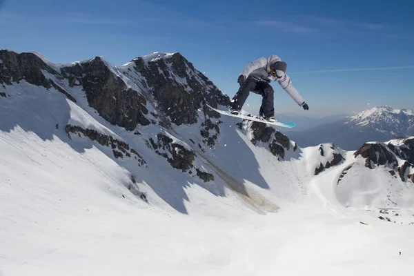 Snowboard jezdec skákat na horách. Extrémní snowboard freeride sport. — Stock fotografie