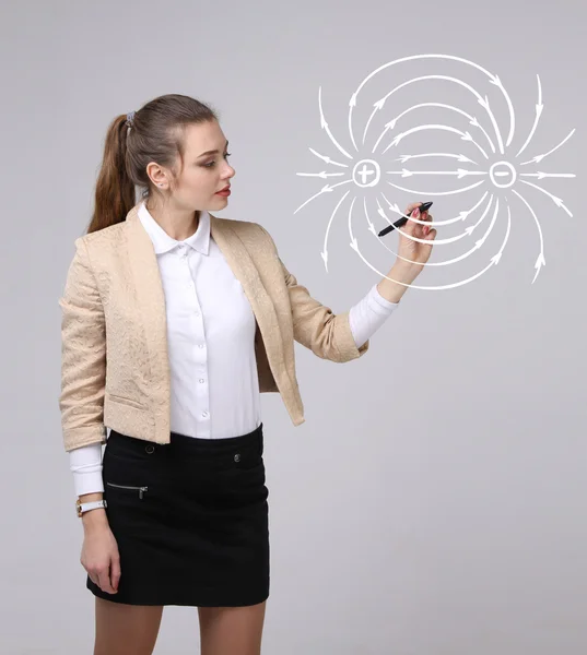 Jeune femme, professeur de physique dessine un diagramme du champ électrique — Photo