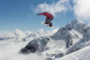 Dağlarda atlayan snowboard binicisi. Ekstrem snowboard serbest spor.