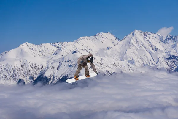 스노보드를 타고 산에 뛰어오르는 사람. 극도의 스노보드 프리에 이드 스포츠. — 스톡 사진
