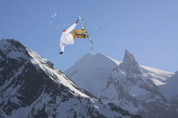 Cavaleiro de esqui a saltar sobre montanhas. Esporte de freeride de esqui extremo . — Fotografia de Stock