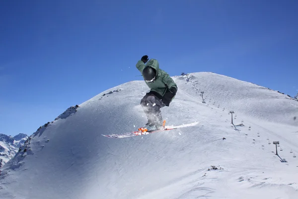 Cavaleiro de esqui a saltar sobre montanhas. Esporte de freeride de esqui extremo . — Fotografia de Stock