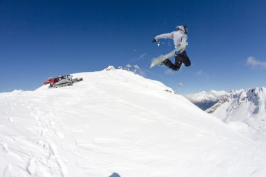 Dağlarda atlayan snowboard binicisi. Ekstrem snowboard serbest spor.
