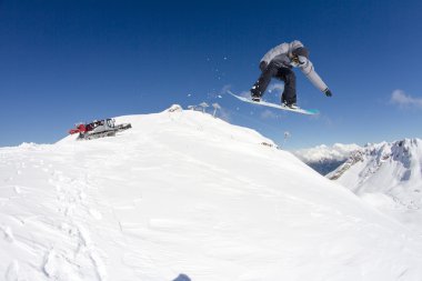 Dağlarda atlayan snowboard binicisi. Ekstrem snowboard serbest spor.