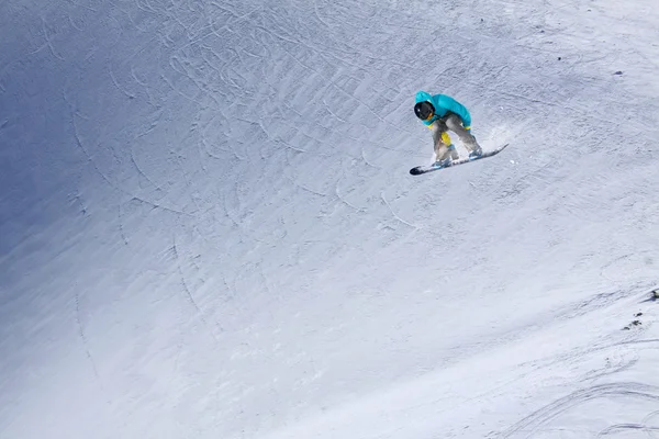 Cavaleiro de snowboard pulando em montanhas. Esporte de freeride de snowboard extremo. — Fotografia de Stock