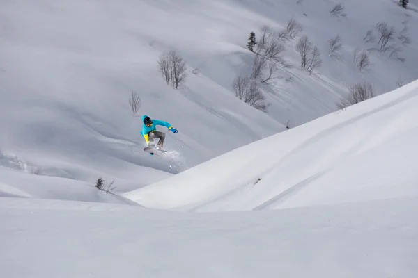 Καβαλάρης snowboard πηδάει στα βουνά. Extreme snowboard ελεύθερο άθλημα. — Φωτογραφία Αρχείου