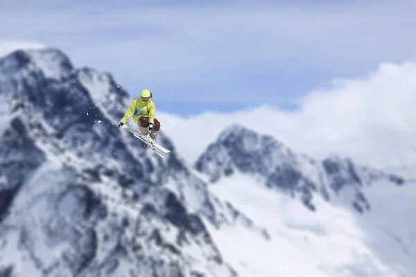 在雪山上跳跃滑雪骑手。极限滑雪随心所欲的运动. — 图库照片