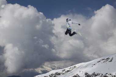 Dağlarda atlayan snowboard binicisi. Ekstrem snowboard serbest spor.