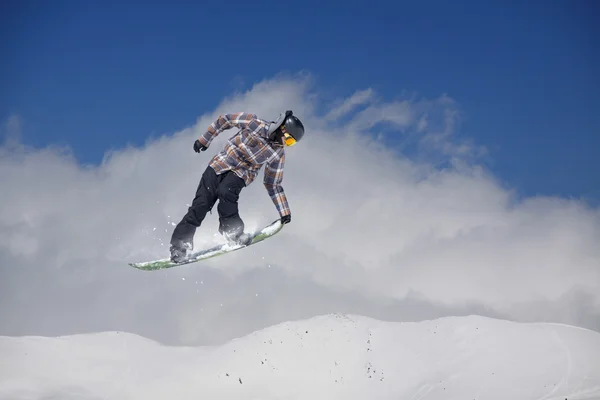 Cavaleiro de snowboard pulando em montanhas. Esporte de freeride de snowboard extremo. — Fotografia de Stock