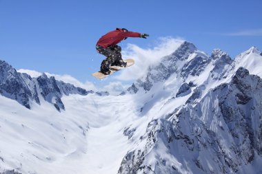 Dağlarda atlayan snowboard binicisi. Ekstrem snowboard serbest spor.
