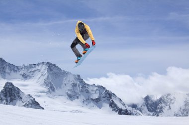 Dağlarda atlayan snowboard binicisi. Ekstrem snowboard serbest spor.