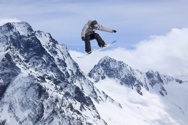 Dağlarda atlayan snowboard binicisi. Ekstrem snowboard serbest spor. — Stok fotoğraf