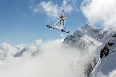 Dağlarda atlayan snowboard binicisi. Ekstrem snowboard serbest spor.