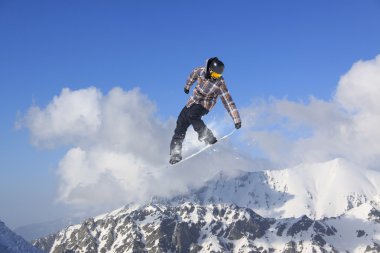 Dağlarda atlayan snowboard binicisi. Ekstrem snowboard serbest spor.