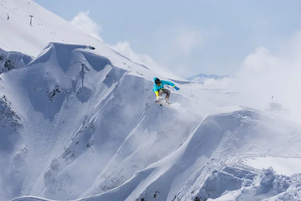 Dağlarda atlayan snowboard binicisi. Ekstrem snowboard serbest spor. — Stok fotoğraf