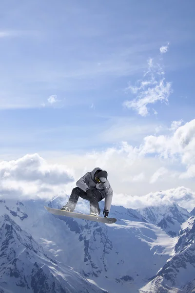 Snowboard rider saltando en las montañas. Extremo snowboard freeride sport. — Foto de Stock