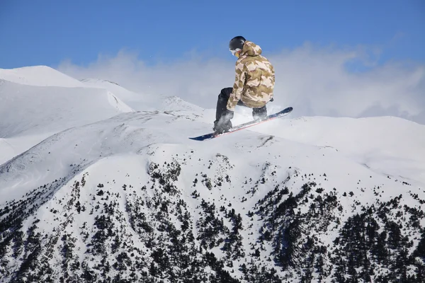 Cavaliere snowboard saltare sulle montagne. Sport estremo freeride snowboard. — Foto Stock