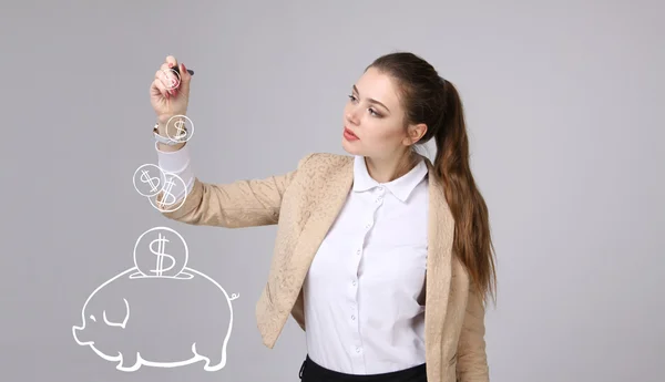 Junge Frau zeichnet ein Sparschwein — Stockfoto