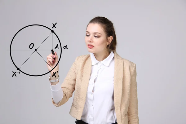 Woman with pen draws geometric shapes on grey background — Stock Photo, Image